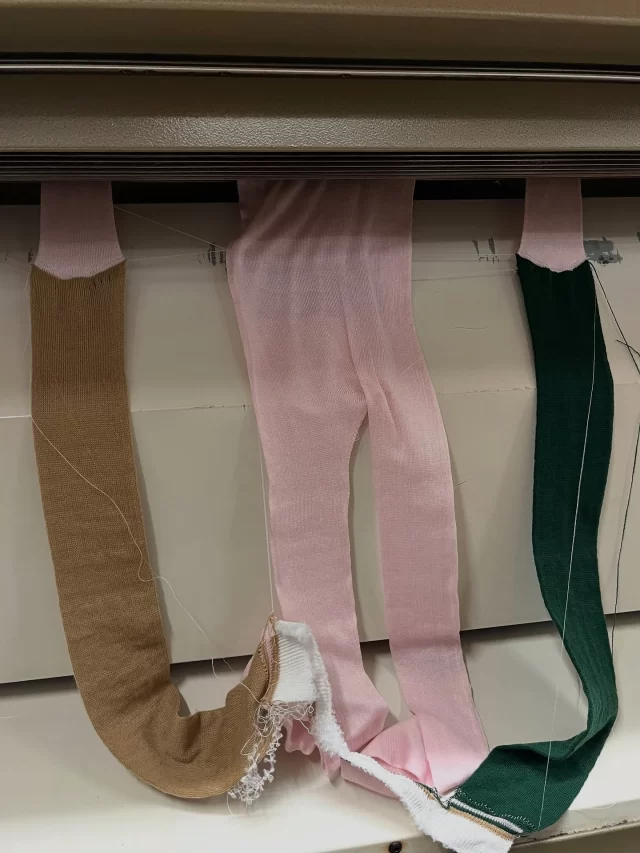 This photo shows a 3D ‘whole garment’ knitting machine, knitting an all-in-one, which is for severe eczema sufferers. 
The sections of green and brown are waste yarn, which has to be knitted in order to have the needles in action knitting, ready for the sleeve sections to be knitted. 
As you can see, it is coming down from the knitting machine on either side of the legs and body.
#mytrainedeye #productdevelopment #trainingcourses #trainingcourse #knitwear #knitweartraining #3dknitting #wholegarmentknitting #shima